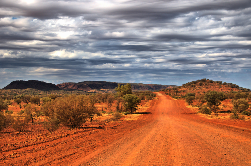A long red dirt road near Alice Springs, Australia provides the perfect backdrop for photos in the Outback!