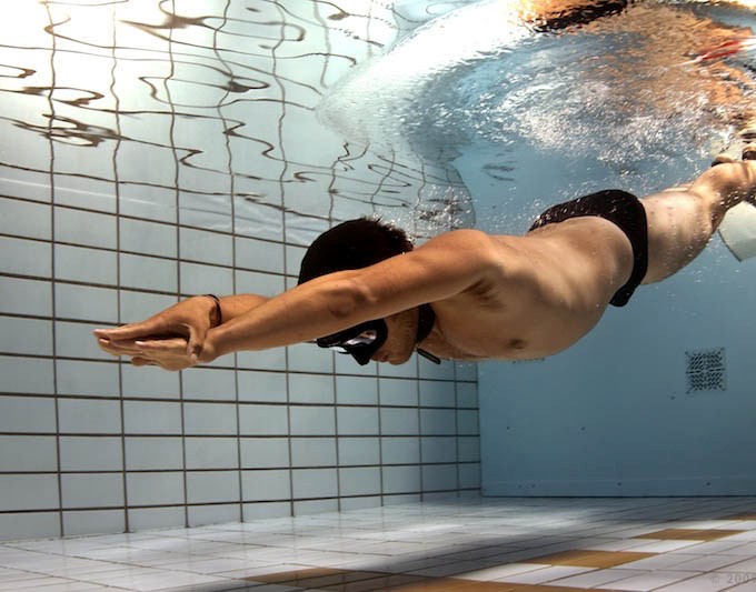 Diver practices swimming underwater in an effort to increase his fitness level