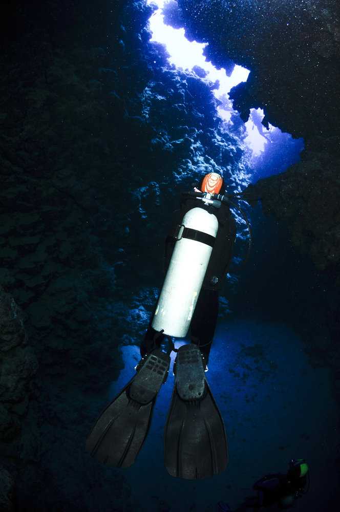 Male diver exiting a cavern off the coast of the Bahamas