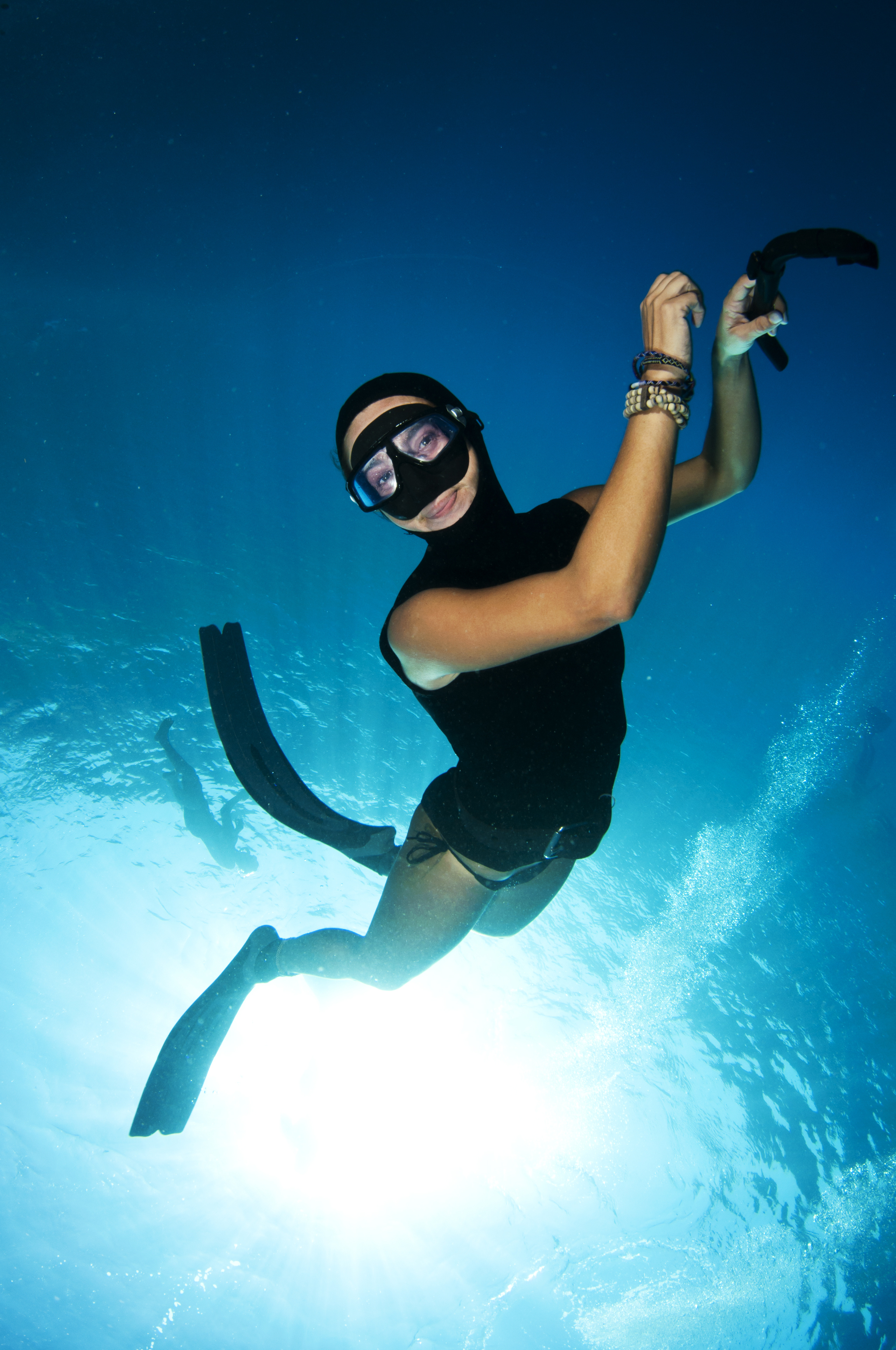 Female freediver smiles for the camera as she enjoys the scenery while practices her skills