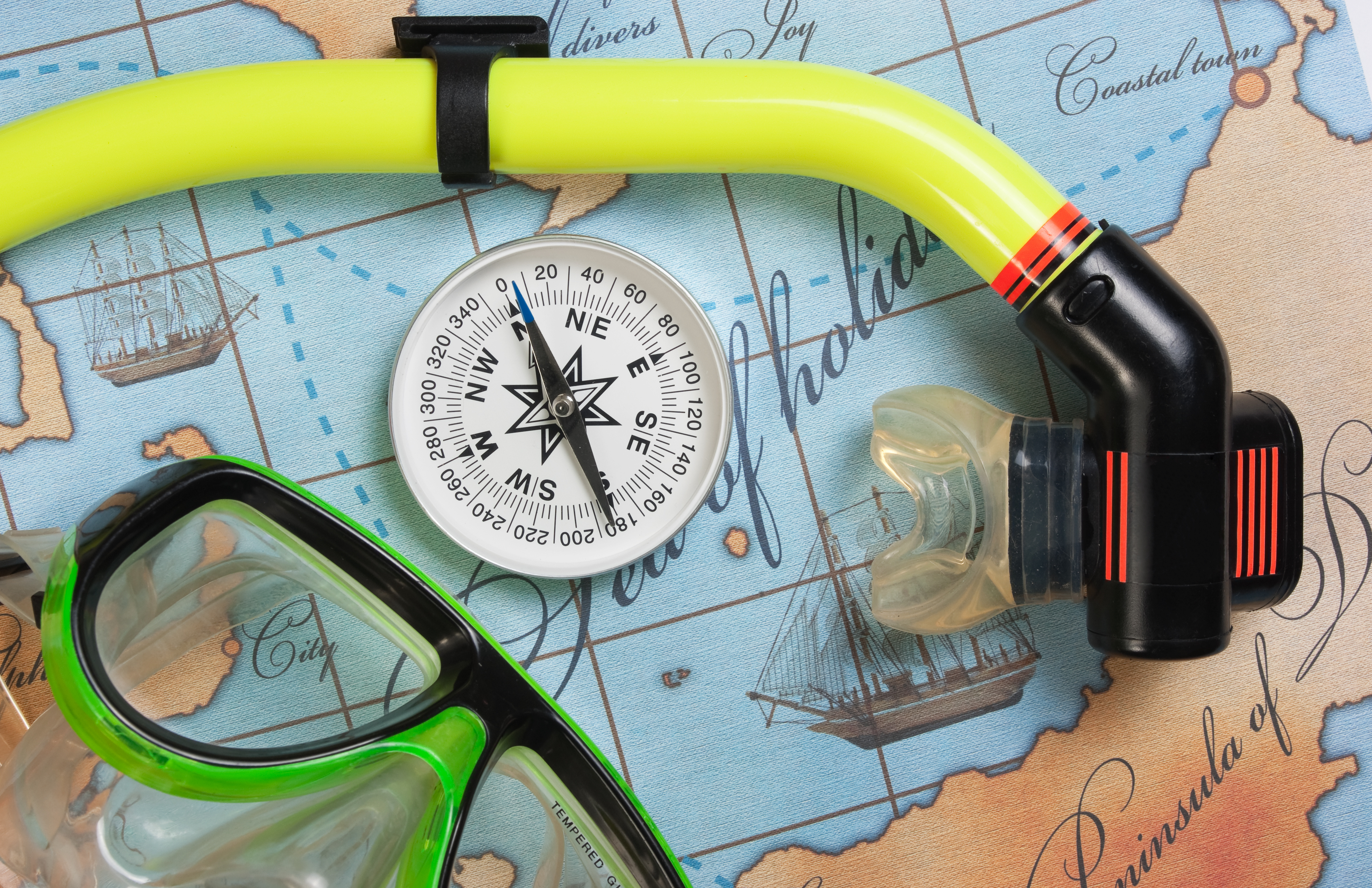 World map, compass, and scuba mask and snorkel and the perfect tools to start planning that next dive vacation