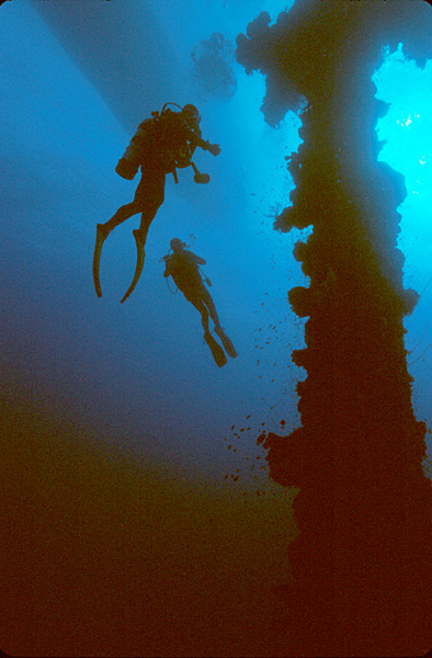 Two divers explore the mast of the Unkai Maru Wreck in Micronesia&#039;s Truk Lagoon