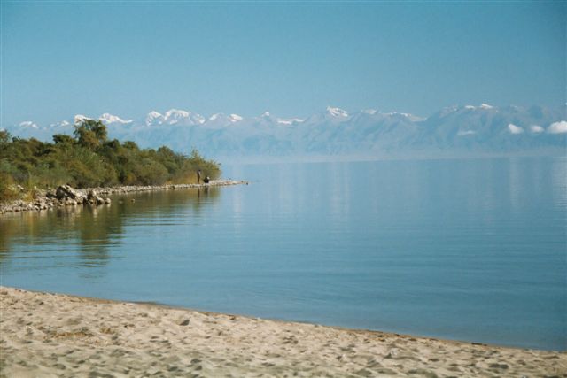 Picturesque view of the south shore of Issyk Kul Lake with snow-capped mountains in the background