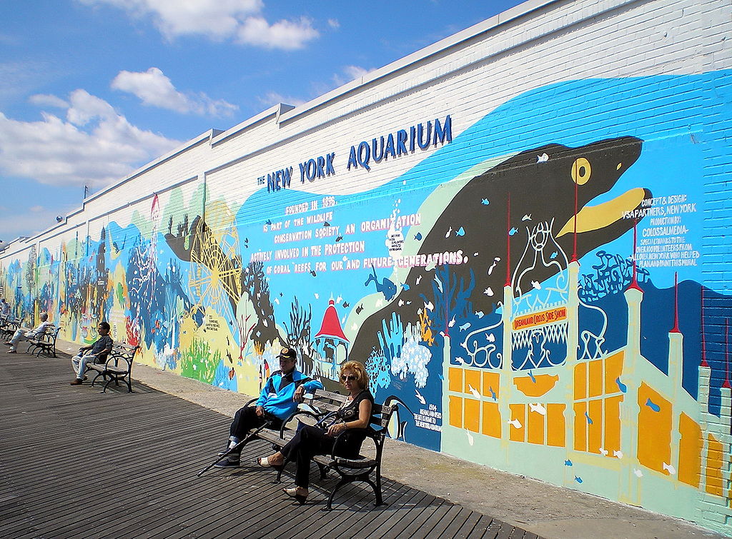 A colorful mural lines the outside of the New York Aquarium in NYC; the inside of the aquarium houses an orphaned walrus named Mitik