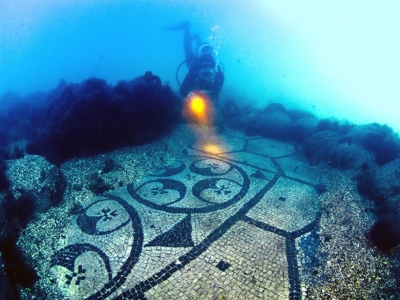 Diver explores the black and white marble mosaic floors of Villa a Protiro in Baia, Italy
