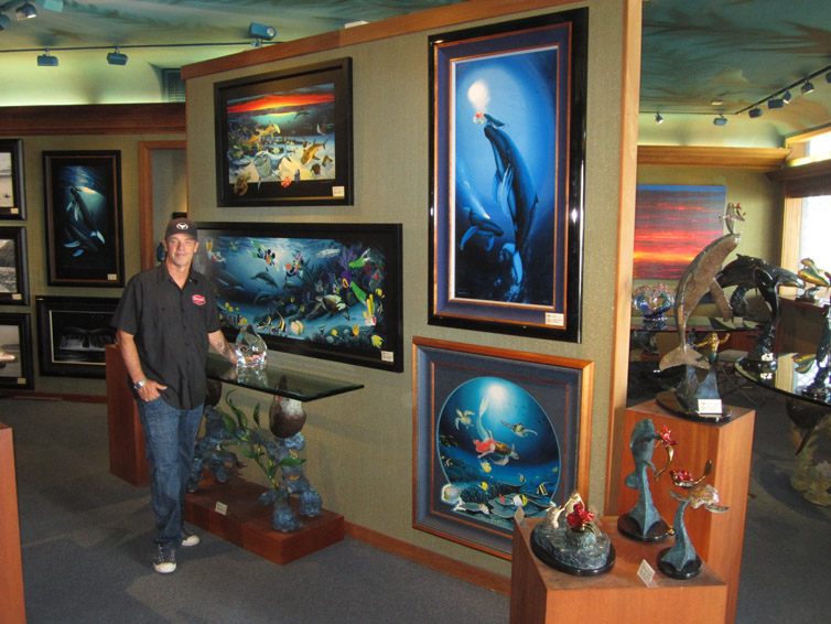 Robert Wyland standing next to several pieces of his fine art and sculptures; they are the perfect gift for any diver