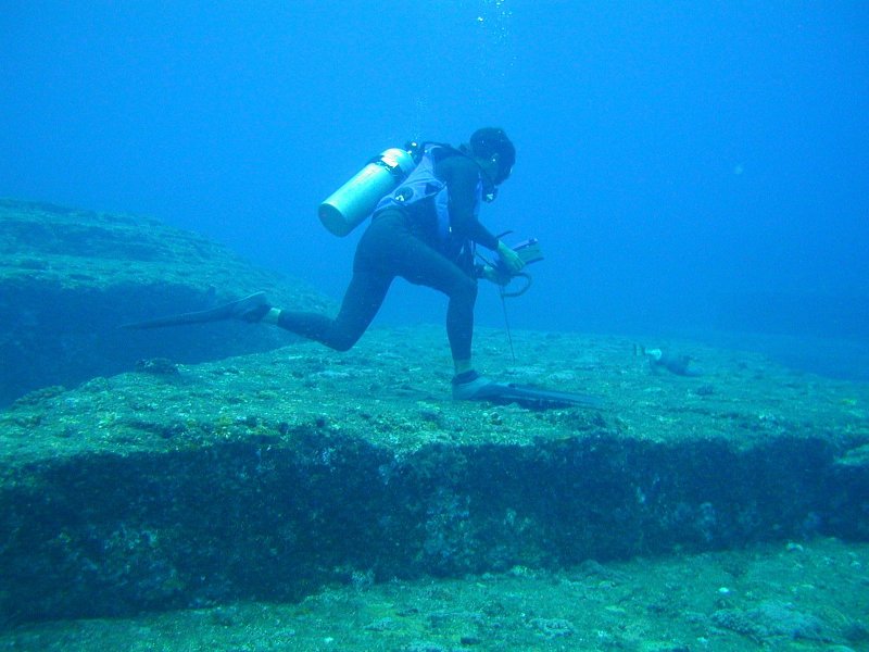 Scuba diver exploring the massive underwater steps at Yonaguni-Jima, Japan