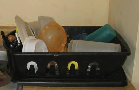 sink strainer with plastic cups, bowls, and utensils