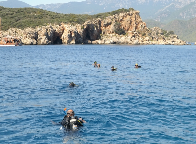 Several divers at a popular mountain lake prepare to descend 