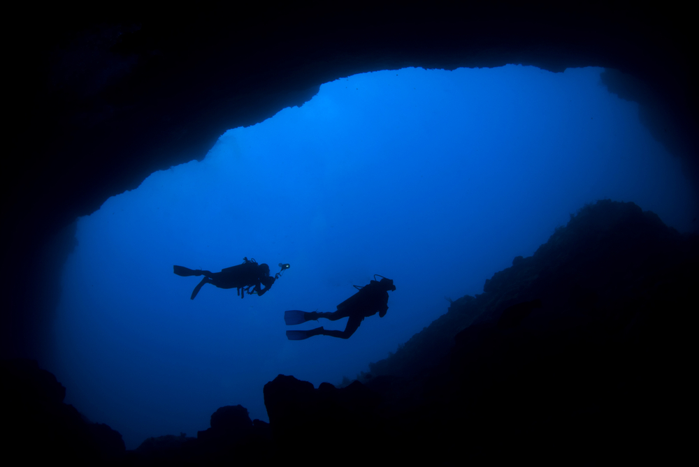 Two divers outside of a cave after their dive