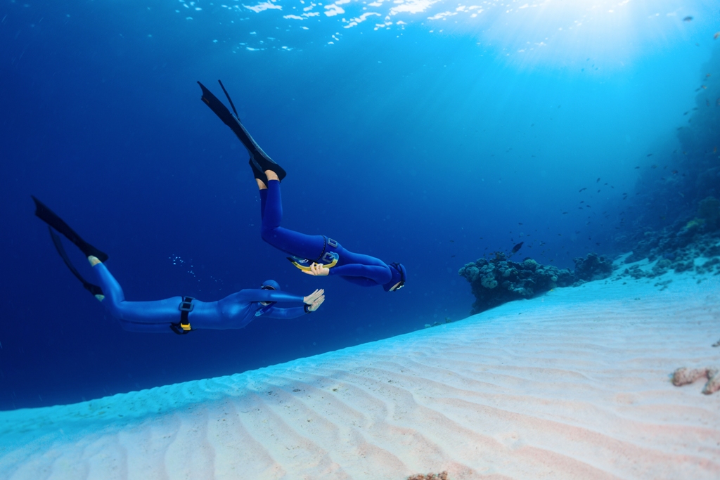 Two freedivers practice the valslava maneuver as the reach new depths