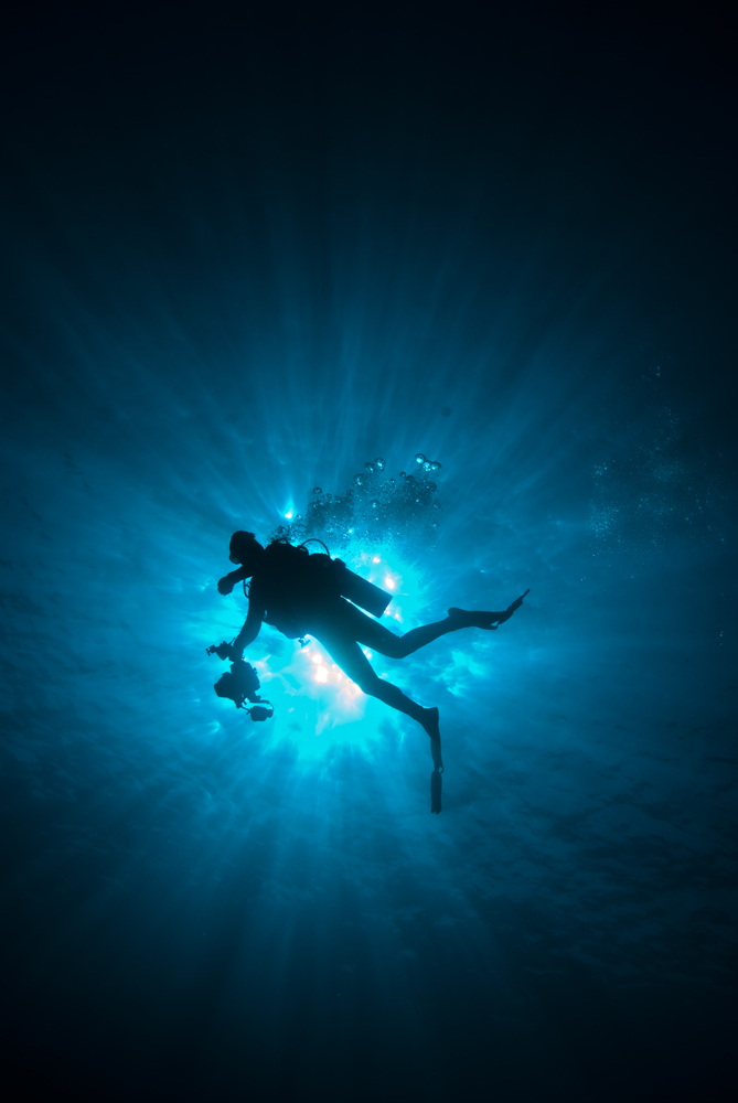 Media Diver with his gear heads back to the dive boat after a busy day