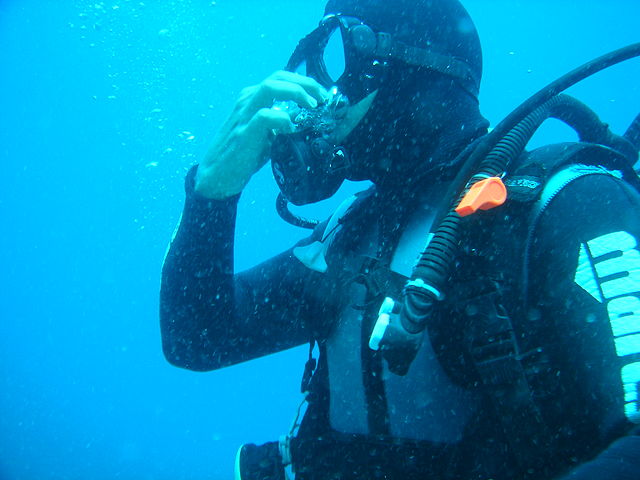 Male diver practices several equalization techniques to equalize the pressure in his ears upon descending
