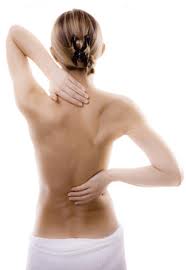 Female diver rubbing the back of her neck and lower back after a dive instead of taking muscle relaxants