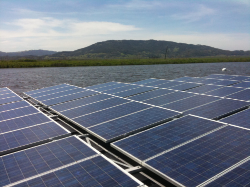 Floating solar energy power station on a lake with mountainous terrain in the backdrop