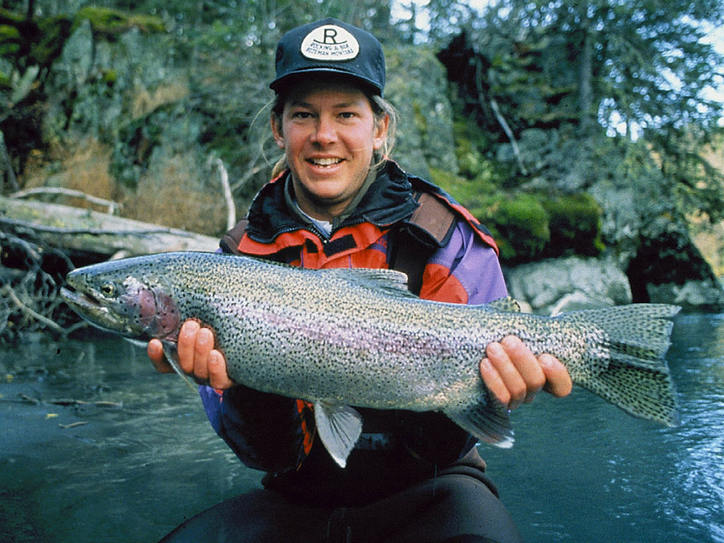 Male holds large rainbow trout, also known as oncorhynchus mykiss, while resting in chilly water; was the fishes' nociceptors affected?