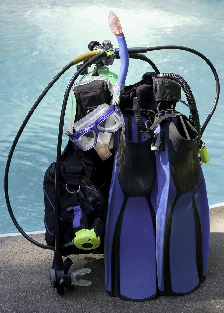 Complete set of dive gear including tank, mask, fins, snorkel, regulator, bc and more lying next to the training pool