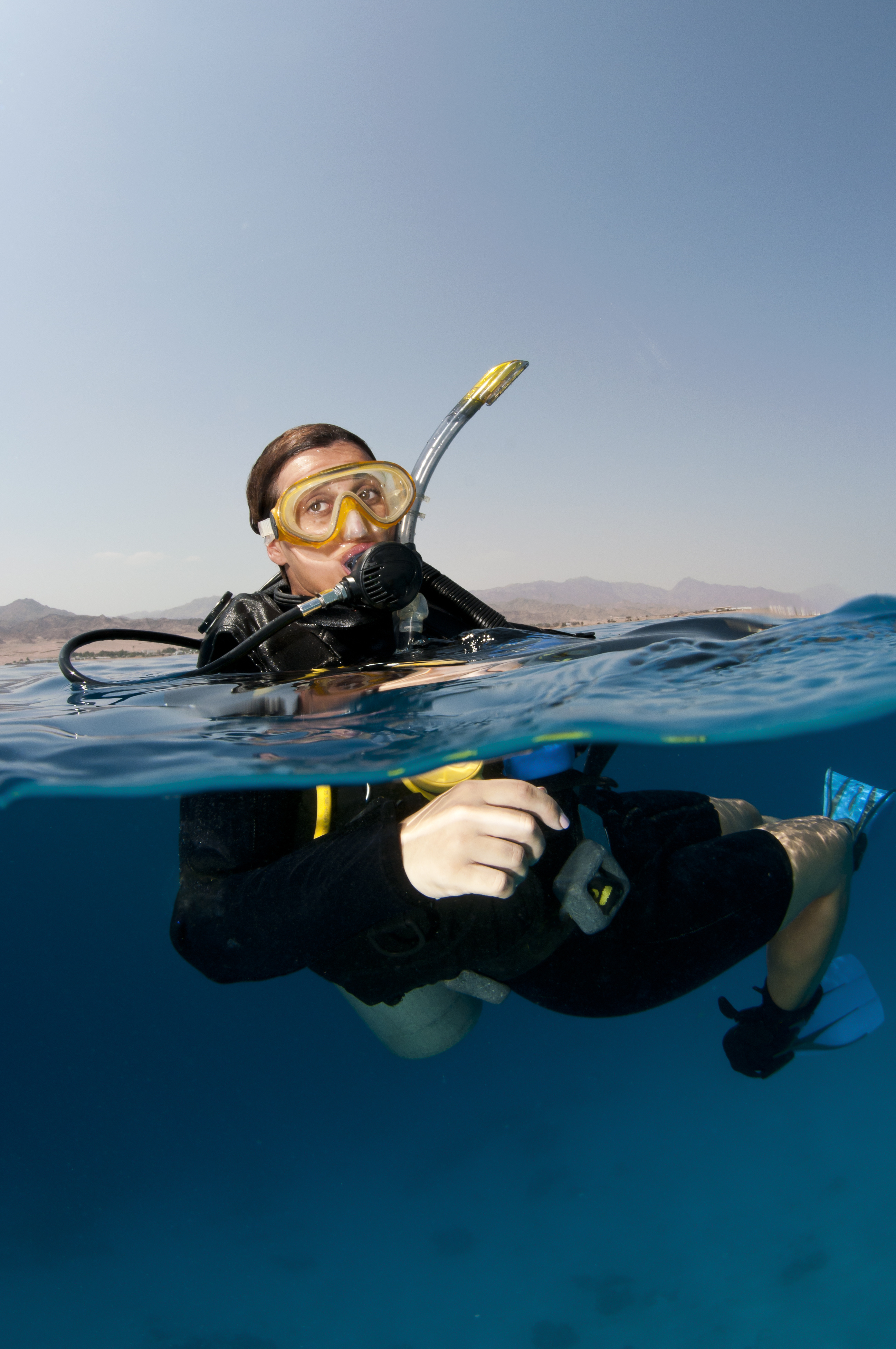 Female diver ensures that her skin and hair is protected prior to dipping below the waterline