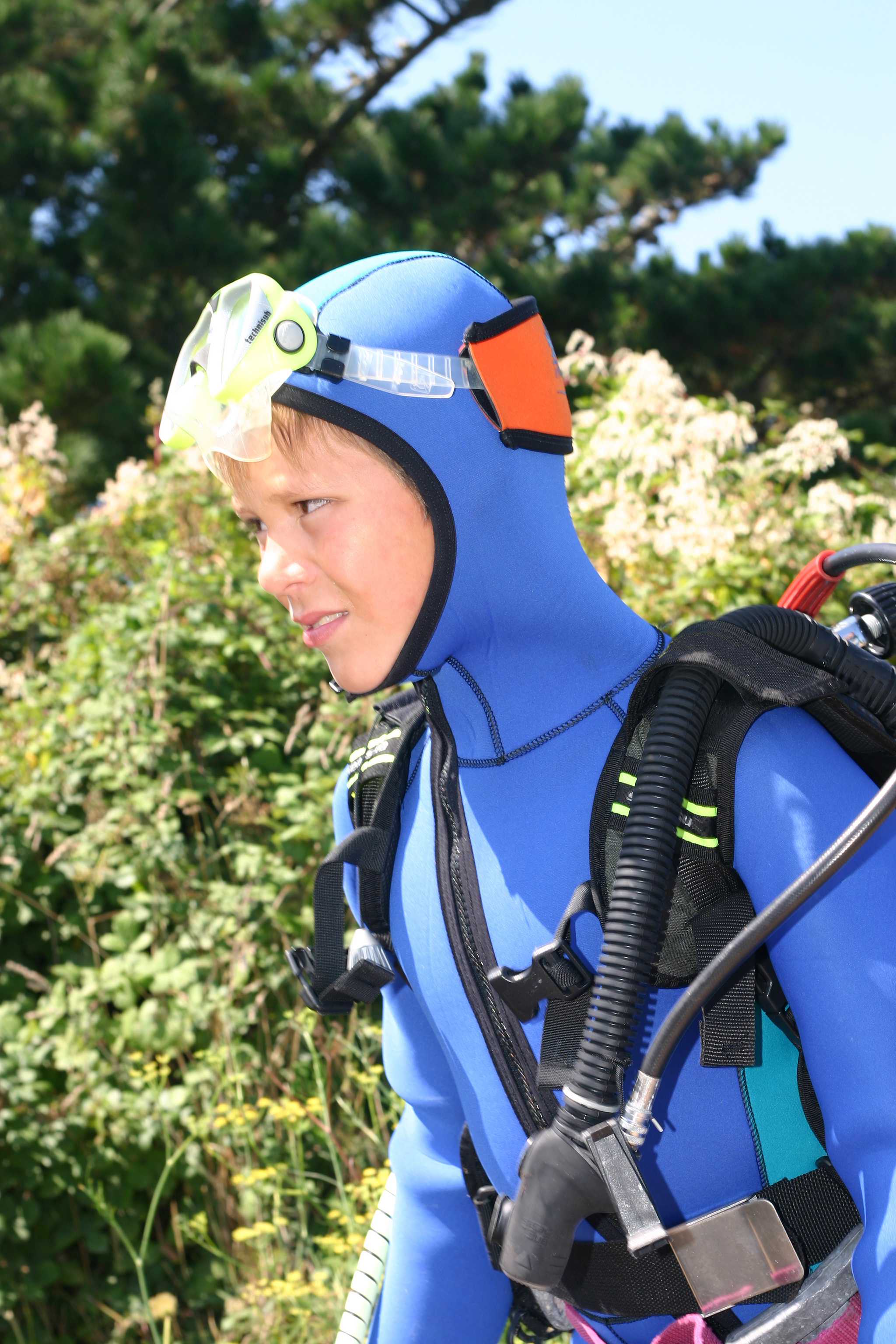 Male diver on his way to the lake uses a hood to keep warm during a cold water dive