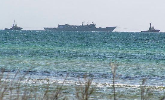 The HMAS Canberra being towed to her final resting spot.