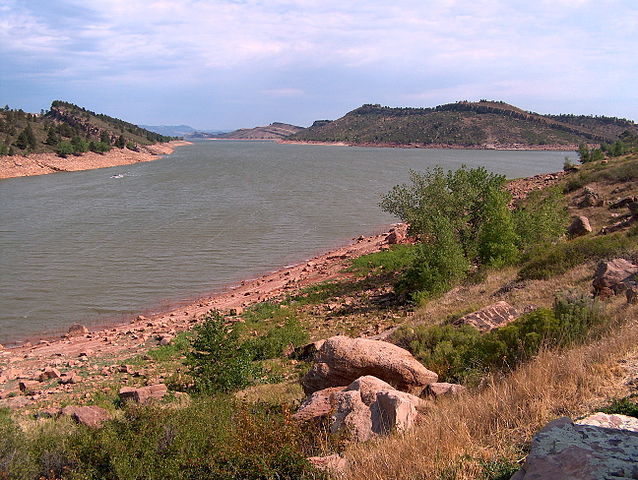 Panoramic view of Horsetooth Reservoir surrounding by red rocky boulders and lush greenery