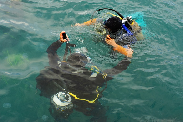 Two divers ready to descend at the Kelvin Grove dive site in Vancouver, Canads