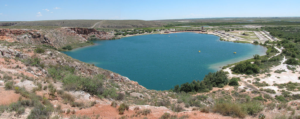 Picturesque view of Lea Lake in New Mexico's Bottomless Lakes State Park surrounded by desert terrain
