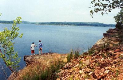 Two men on a ledge look at over Bull Shoals Lake in Arkansas' White River Valley