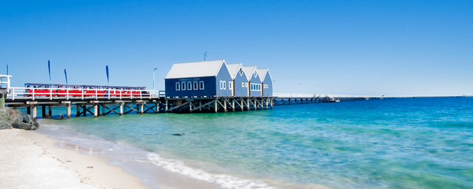 Busselton Jetty in Australia with the clear blue water moving towards the shore