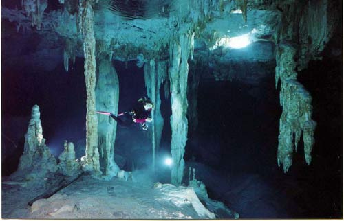 Diver explorers the underwater tunnels filled with stalactites in the Dos Ojos Cenote in Mexico&#039;s Riviera Maya