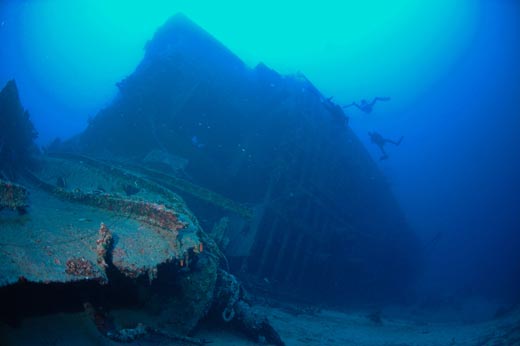Several divers approach and explore the wreckage of the Duchess of York wreck as she lay scattered about the Kalkan reef in Turkey