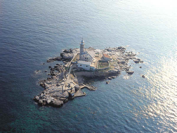 Aerial view of lighthouse on Faro Island as the sun goes down