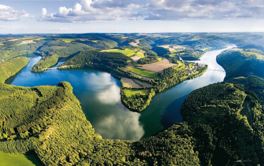 Panoramic view of Haute Sure Lake in Luxembourg with lush greenery surrounding it