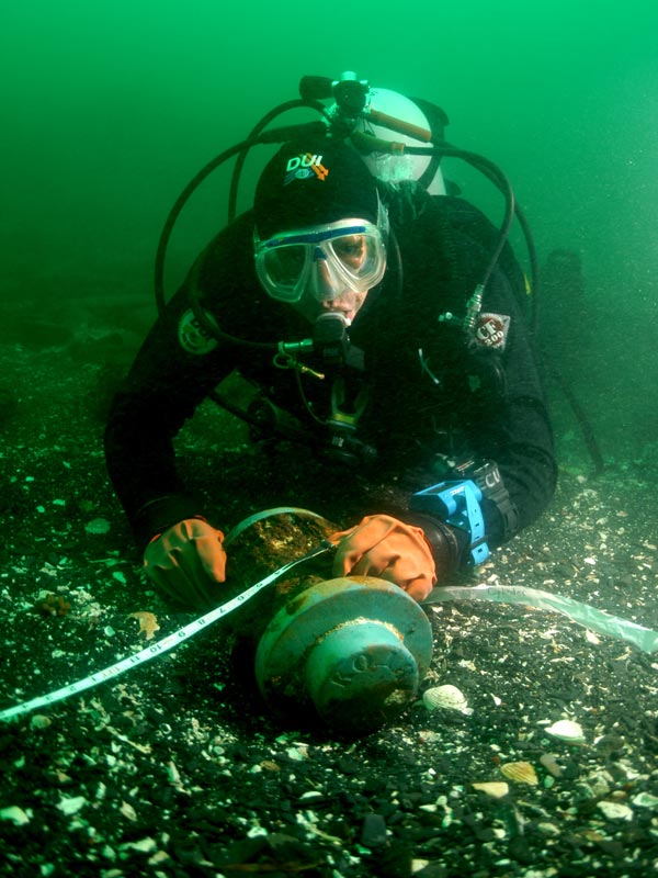 Diver exploring the hub of the Kad&#039;yak&#039;s wheel revealing its name in Russian