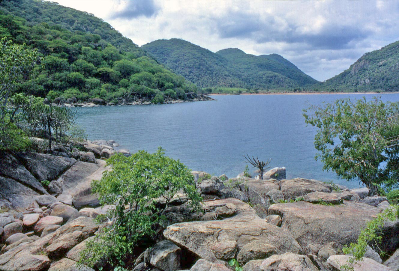 Topside view of Lake Malawi with green mountains and colorful rocks providing the perfect backdrop for photos before diving into warm, freshwater filled with marine life