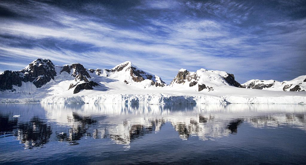Panoramic view of snowcapped mountains lining the Lemaire Passage in Antarctica