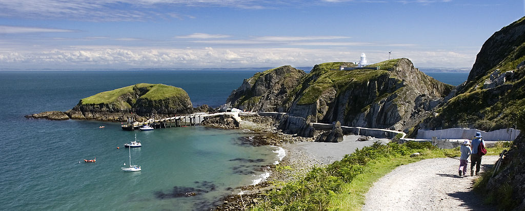 Panoramic of the the jetty on England's Lundy Island surrounded by blue water and lush greenery