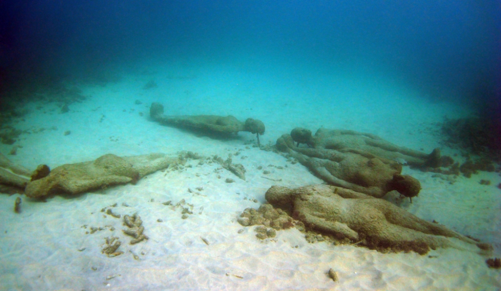 Underwater sculptures line the sandy bottom at Grenada&#039;s underwater sculpture park